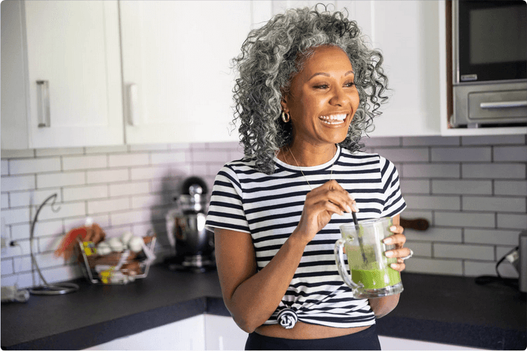 Healthy older woman drinking green smoothie